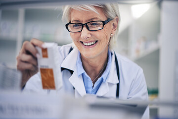 Happy woman, pharmacist and reading medication on shelf for inventory, diagnosis or prescription at pharmacy. Mature female person, medical or healthcare professional checking medicine in drugstore