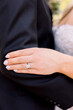 © DPN - Bride in dress rests hand on husbands arm closed fingers displaying wedding ring