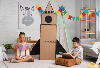 Wall Mural - Cute little children with adventure books and cardboard rocket at home