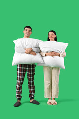 Sticker - Young couple with pillows on green background