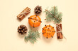 Pomander balls with Christmas tree branches, cones and cinnamon on yellow background