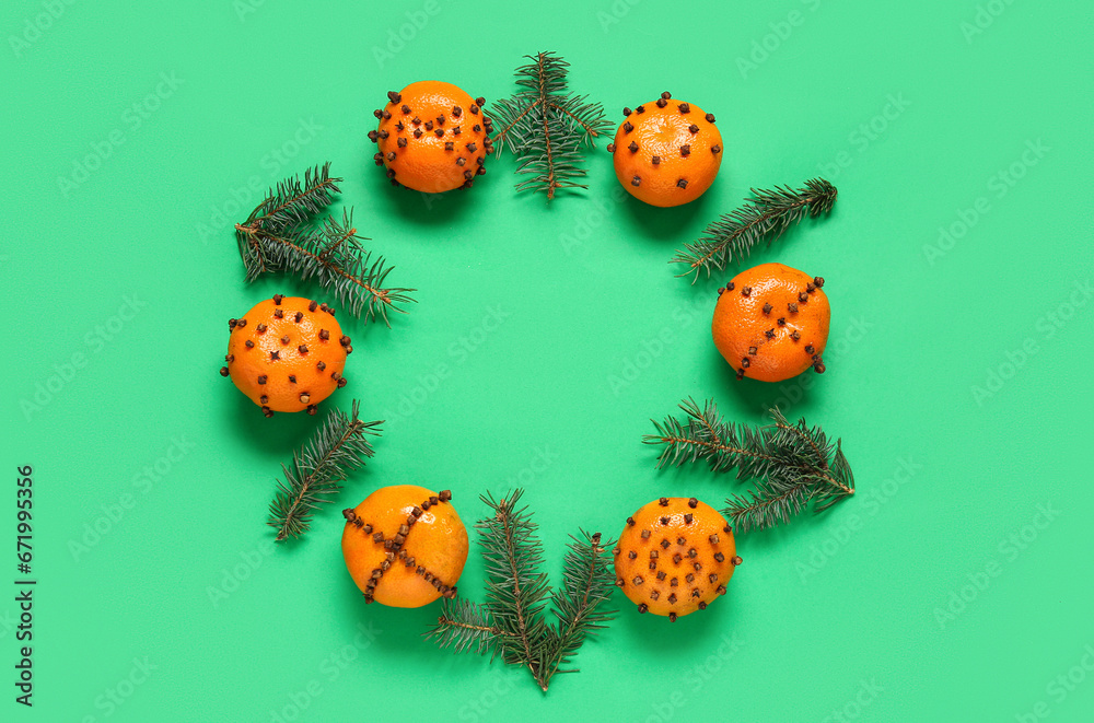 Frame made of pomander balls with Christmas tree branches on green background
