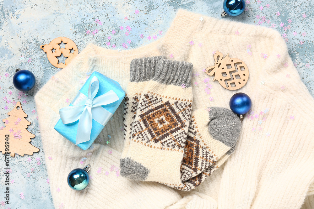 Beautiful composition with warm socks and Christmas decor on blue background