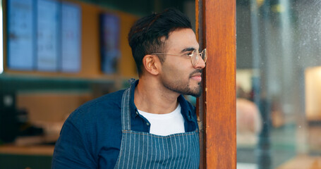 Poster - Small business, coffee shop and a man waiter thinking about hospitality service at the entrance to a restaurant. Face, idea and a young startup entrepreneur working as a barista in a local cafe