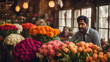 An Indian man selling wide variety of colorful flowers in his shop.