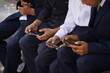 © Vladimir - Almaty, Kazakhstan - 09.06.2023 : Children in school uniforms play mobile games on a bench near the school.