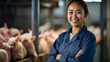 A smiling asian female pig farmer stands with his arms folded in the poultry shed .Generative AI