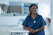 © Wavebreak Media - Portrait of happy african american female doctor wearing scrubs in hospital, copy space