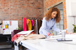 © Wavebreak Media - Focused biracial female fashion designer working and making notes in sunny studio