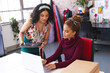 © Wavebreak Media - Two biracial female fashion designers working with laptop and tablet in sunny studio
