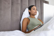 © Wavebreak Media - Busy biracial woman sitting and using laptop in bedroom