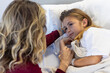© Wavebreak Media - Caucasian mother holding hand of sick daughter patient lying in hospital bed