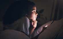 Woman, cellphone and bed in night, reading or texting for chat, blog or social media post in apartment. Girl, smartphone and thinking in dark bedroom for online search, games or video on web in house