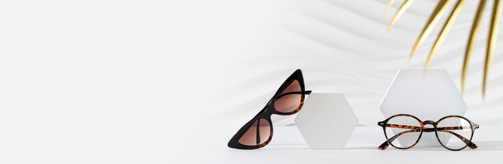 Sticker - Sunglasses and glasses sale concept. Trendy cat eye frame sunglasses and spectacles on white background with golden palm leaf. Fashion eyewear. Copy space. Optic store discount web line, sale banner.