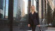 © SERGEI - Pretty 30s business woman take walk. Sexy lady boss city stroll. Attractive 40 years old businesswoman. Successful top manager step. Confident serious girl gait. Person wear black job suit close up.