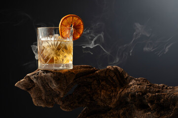 Wall Mural - Smoked old fashioned cocktail with ice and dried orange slice.