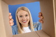 © Atlas - An attractive blonde looks into a cardboard box
