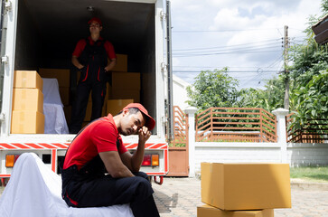 Man in accident slipped and fall the floor in front of the house, Indian worker tired exhausted carry heavy box overloading, life insurance, welfare benefits, compensation for employees in company