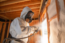 A Construction Worker Applying Spray Foam Insulation Between Wall Studs, Making A Home More Energy-efficient