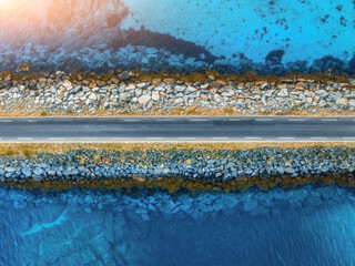 Wall Mural - aerial view of road, sea, stones at sunset in lofoten islands, norway. landscape with beautiful brid