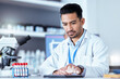 © Phindulo T/peopleimages.com - Scientist man, tablet and typing in laboratory with thinking, medical research and blood for pharma development. Young pharmaceutical expert, digital touchscreen or focus for innovation in healthcare