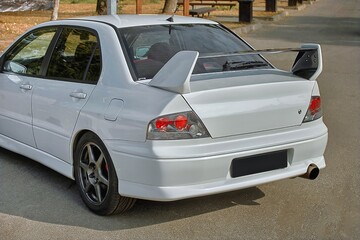 Wall Mural - White car on a street background. Modern city sport car with a spoiler wallpaper