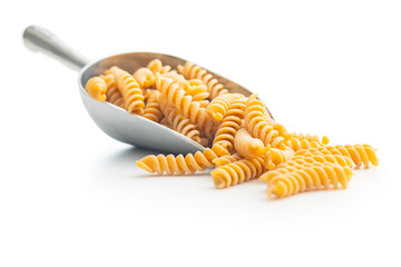 Wall Mural - Raw whole grain fusilli pasta. Uncooked pasta in scoop isolated on white background.