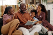 © AnnaStills - Father of family reading book on Martin Luther King Jr ideas to his wife and two kids