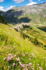 Mountain valley with a small town on hill in Italy