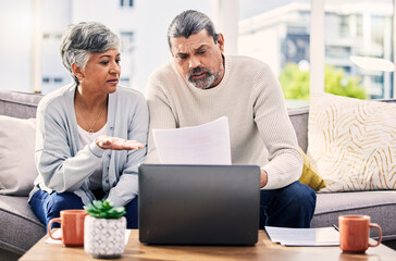 Poster - Senior couple, paperwork and stress on laptop with financial documents, taxes or retirement questions at home. Planning debt, computer and people on sofa for life insurance, bills or asset management