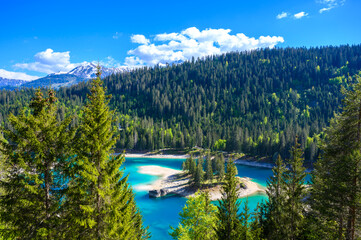 Wall Mural - Small island in the middle of Cauma Lake (Caumasee) with crystal blue water in beautiful mountain landscape scenery at Flims, Graubuenden - Switzerland