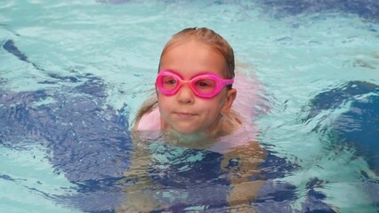 Wall Mural - Child diving in swimming pool. Toddler kid jumping into the water in goggles learning to swim. Girl having fun in water, splashing in aquapark