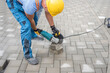 © Sabrewolf - Laying interlocking paving. A worker sawing the paving stone with an angle grinder.