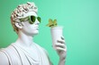 White sculpture of Apollo wearing green glasses with glass in hand on green background with copy space.