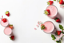 
Glasses of strawberry milkshake and ingredients on white background, top view , copy space text