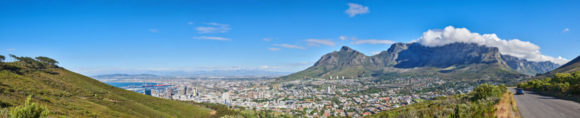 Wall Mural - Mountain landscape and panorama view of coastal city, residential buildings or infrastructure in famous travel or tourism destination. Copy space and scenic blue sky of Table Mountain in South Africa