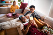 © Marko Geber - Diverse young roommates relaxing on the couch in their apartment