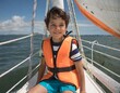 Niño caucásico sonriente en un barco de vela 