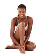 © Shrikant/peopleimages.com - Skin care, portrait and happy woman on floor for dermatology, epilation and relax in underwear. African model on the ground with body cosmetics or beauty and isolated on a transparent PNG background