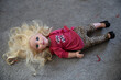doll laying on ground with blonde hair