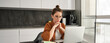 © Mix and Match Studio - Freelancing, work from home concept. Young woman sitting with laptop in kitchen, freelancer digital nomad doing her job on remote, using computer, looking thoughtful, thinking