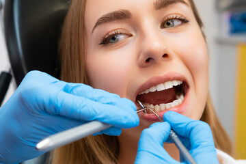 Wall Mural - A dentist examining a patients teeth in a modern dental clinic. 