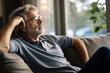 © AI_images - Pensive mature Caucasian grey-haired man relax on sofa in living room look in distance thinking dreaming. Thoughtful senior 70s grandfather rest on couch at home