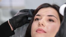 The Girl Beautician Marks With The Help Of Thread Eyebrow Tattoo. Permanent Tattooing Of Eyebrows.