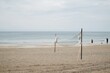 © Wirestock - Volleyball goal on a sandy beach on a cloudy day