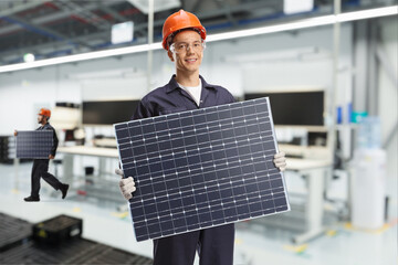 Wall Mural - Workers inside a factory carrying solar panels