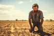Distressed farmer in barren field background with empty space for text 