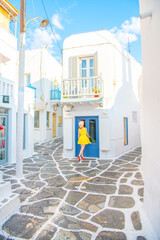 Naklejka na meble Woman in yellow dress at the Streets of old town Mykonos during a vacation in Greece, Little Venice Mykonos Greece