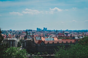 Poster - Aerial view of the cityscape of Prague with its vibrant red rooftops, seen from a distance