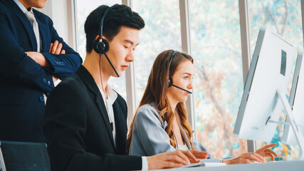 Wall Mural - Business people wearing headset working in office to support remote customer or colleague. Call center, telemarketing, customer support agent provide service on telephone video conference call. Jivy